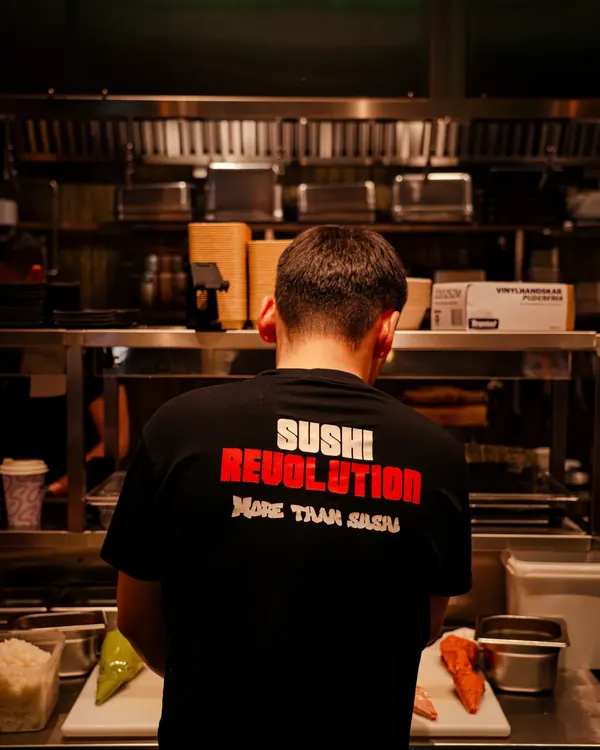 Kock i Sushi Revolutions kök, i tröja med texten More than sushi