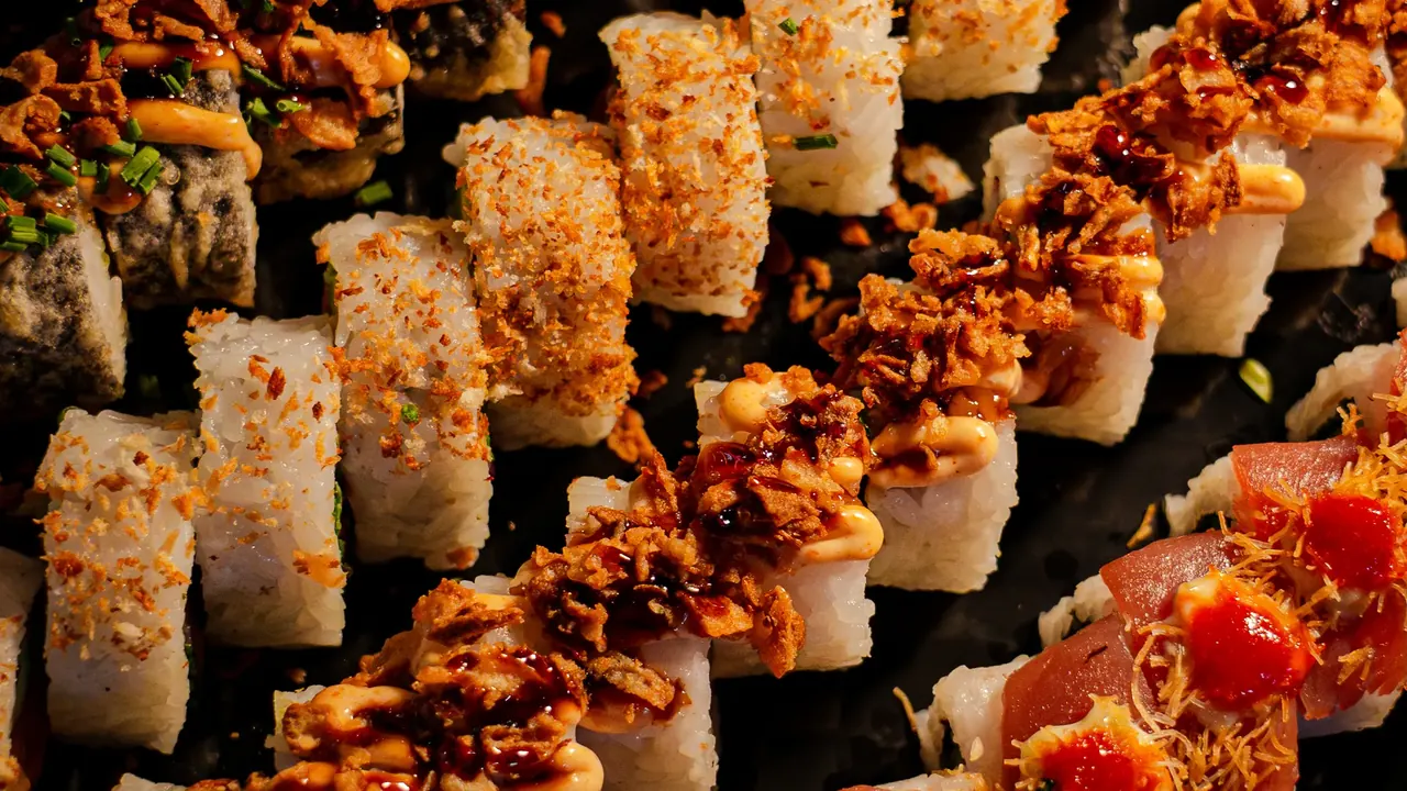 Stor sharing-bricka uppifrån med rader av rullar, crunch och tobiko